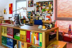 Ein Lernstübchen, bunt gefüllt mit Regalen voller Unterrichtsmaterialien und Post-It